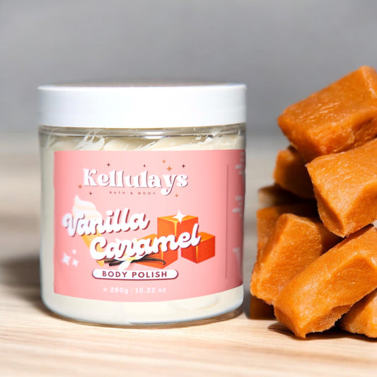 Jar of Kellulays ‘Vanilla Caramel’ body polish with a pink label, featuring images of caramel cubes. Stack of caramel pieces beside the jar.
