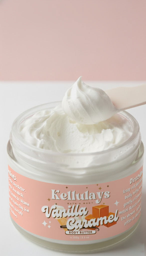 A close up of Kellulays Vanilla Caramel whipped body butter, showing fluffy, cloud like swirl being scooped with a spatula against a soft pink background. The creamy texture highlights the products light, whipped consistency.